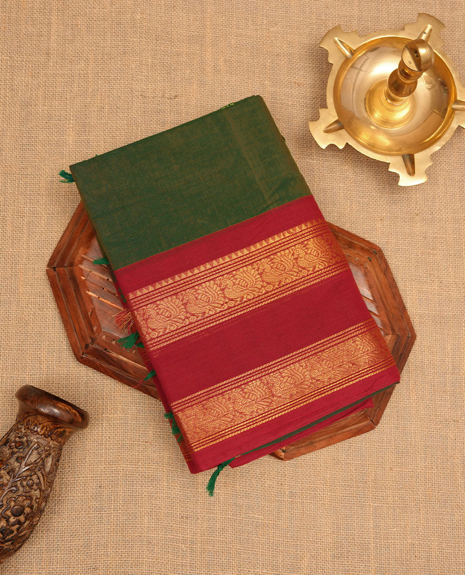 Dark Green colour chettinad cotton saree featuring Elegant plain body, contrast Red colour border with gold zari border, pallu and paired with matching blouse.