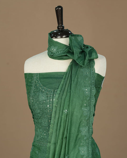 Green colour churidhar material featuring self colour thread and sequins work on body, paired with matching bottom and Dupatta.