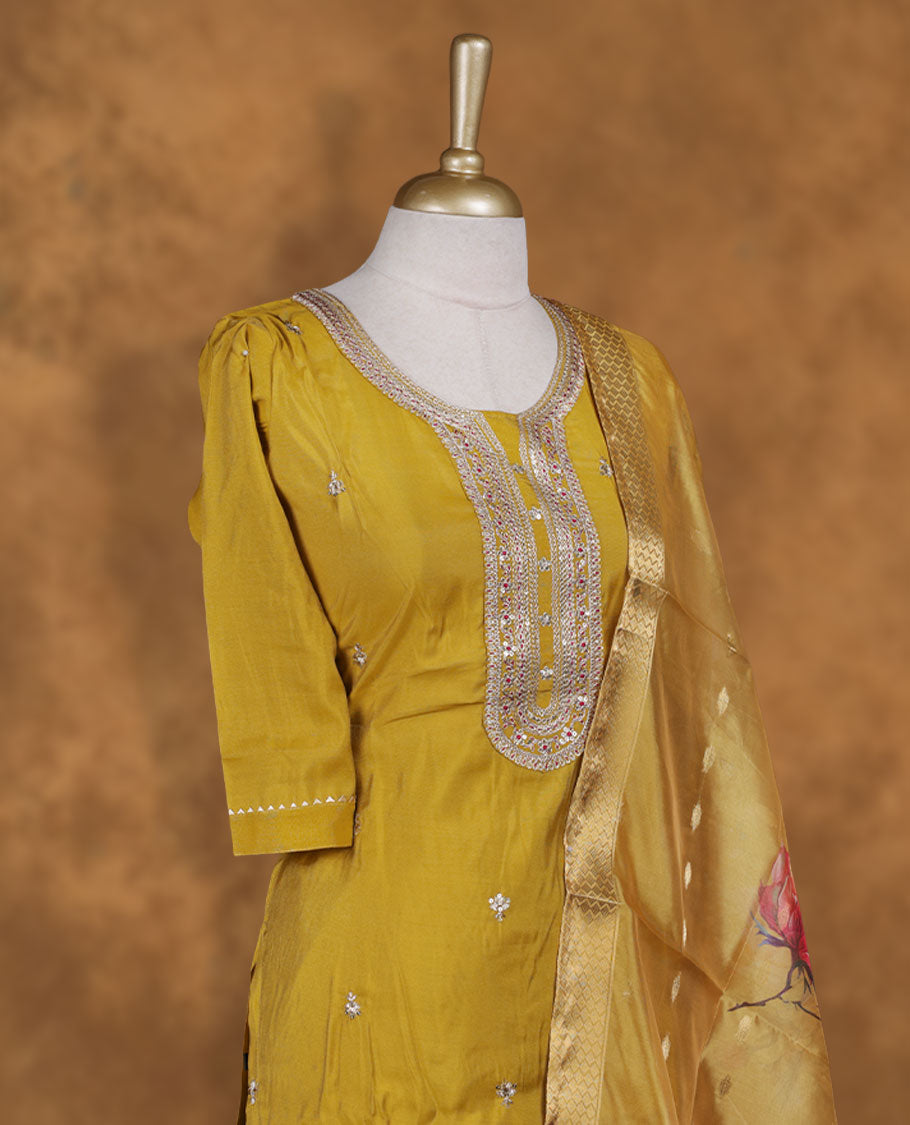 Olive yellow colour churidar set featuring elegant white thread embroidery on the neckline, sleeves, and scattered motifs across the body, Paired with a matching floral printed pattern dupatta