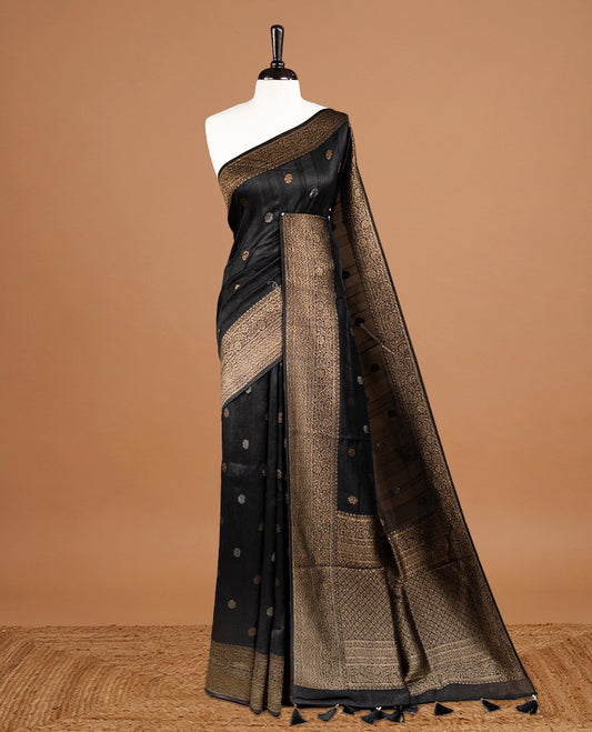 Black colour Semi banaras tussar georgette Saree featuring Antique zari motifs on body, enhanced with antique zari border, paired with a matching blouse piece.