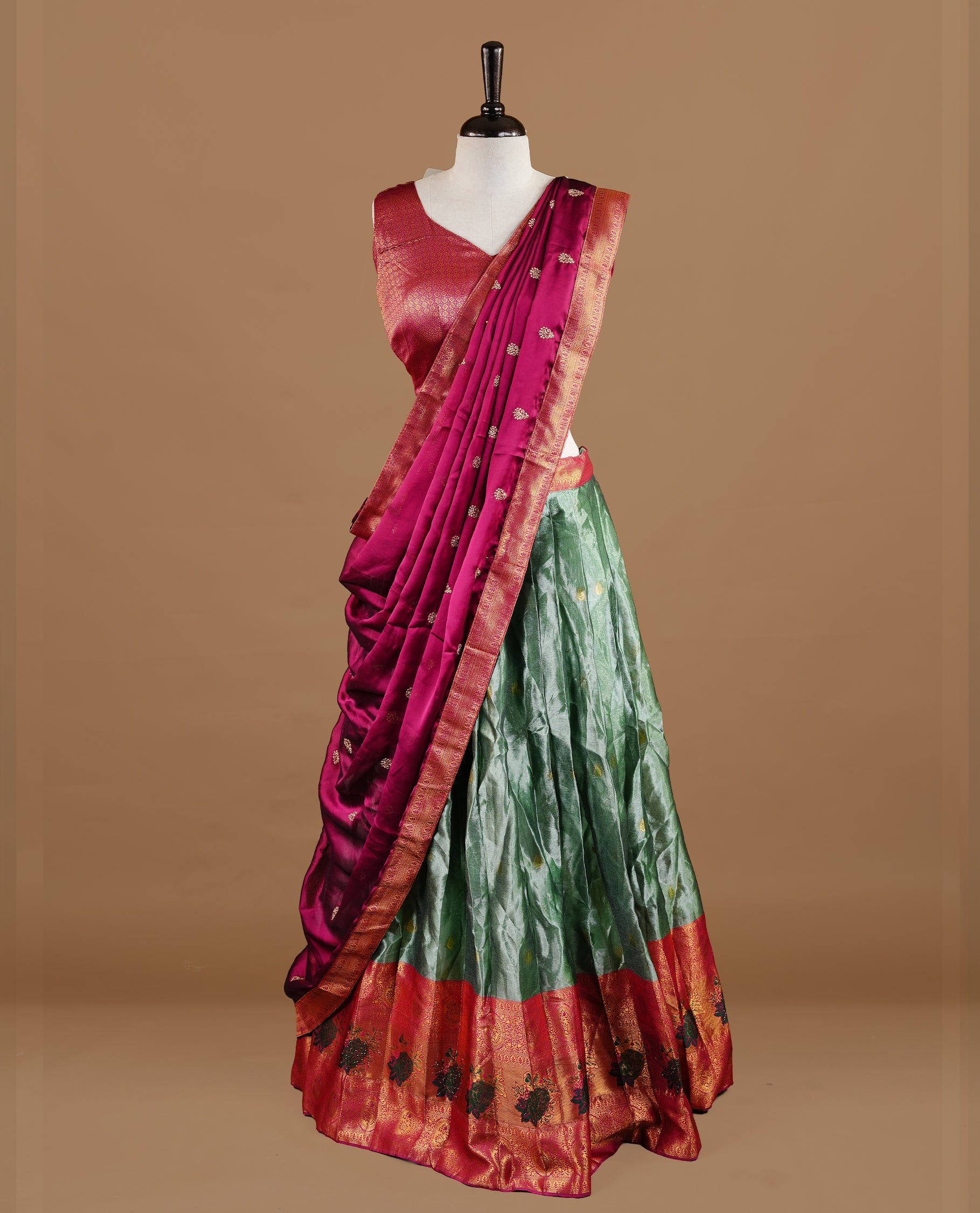 Green colour Half saree featuring green colour skirt with contrast magenta colour traditional border, paired with matching stitched blouse, matching dupatta.