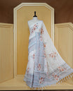 Cream colour semi linen saree featuring Floral printed buttas on body, complemented by contrast Grey colour border, comes with matching blouse piece.