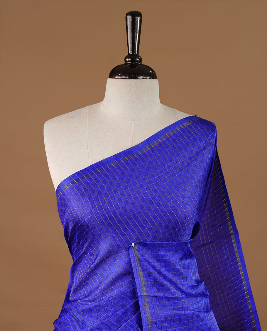 Blue colour Semi Tussar saree featuring an elegant zari fancy check pattern on the body, highlighted with a small border for a refined look. Comes without a blouse piece.