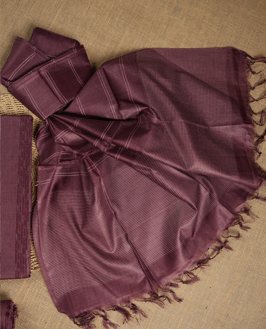 Dark mauve colour tussar suit material with elegant woven stripes & Comes with a matching dupatta adorned with tassels and a plain bottom.