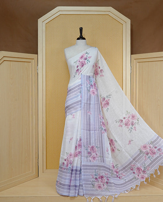 Cream colour semi linen saree featuring Pink colour floral print on body, complemented by contrast Strip pattern border, comes with matching blouse piece.