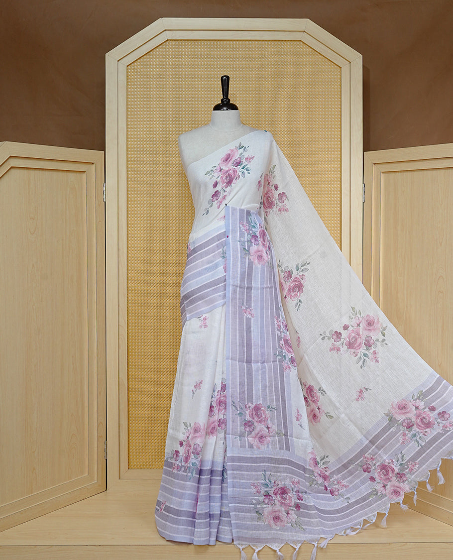 Cream colour semi linen saree featuring Pink colour floral print on body, complemented by contrast Strip pattern border, comes with matching blouse piece.