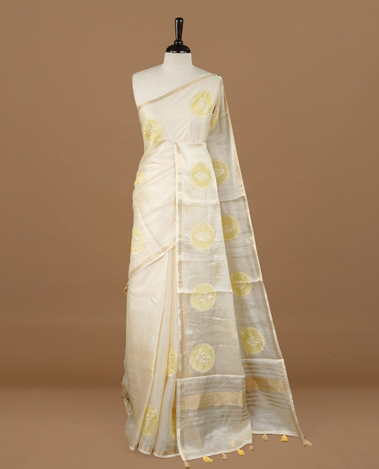 Cream colour Tussar saree featuring yellow colour circle pattern with chikankari embroidery work, highlighting gold zari simple border, paired with matching unstitched blouse.