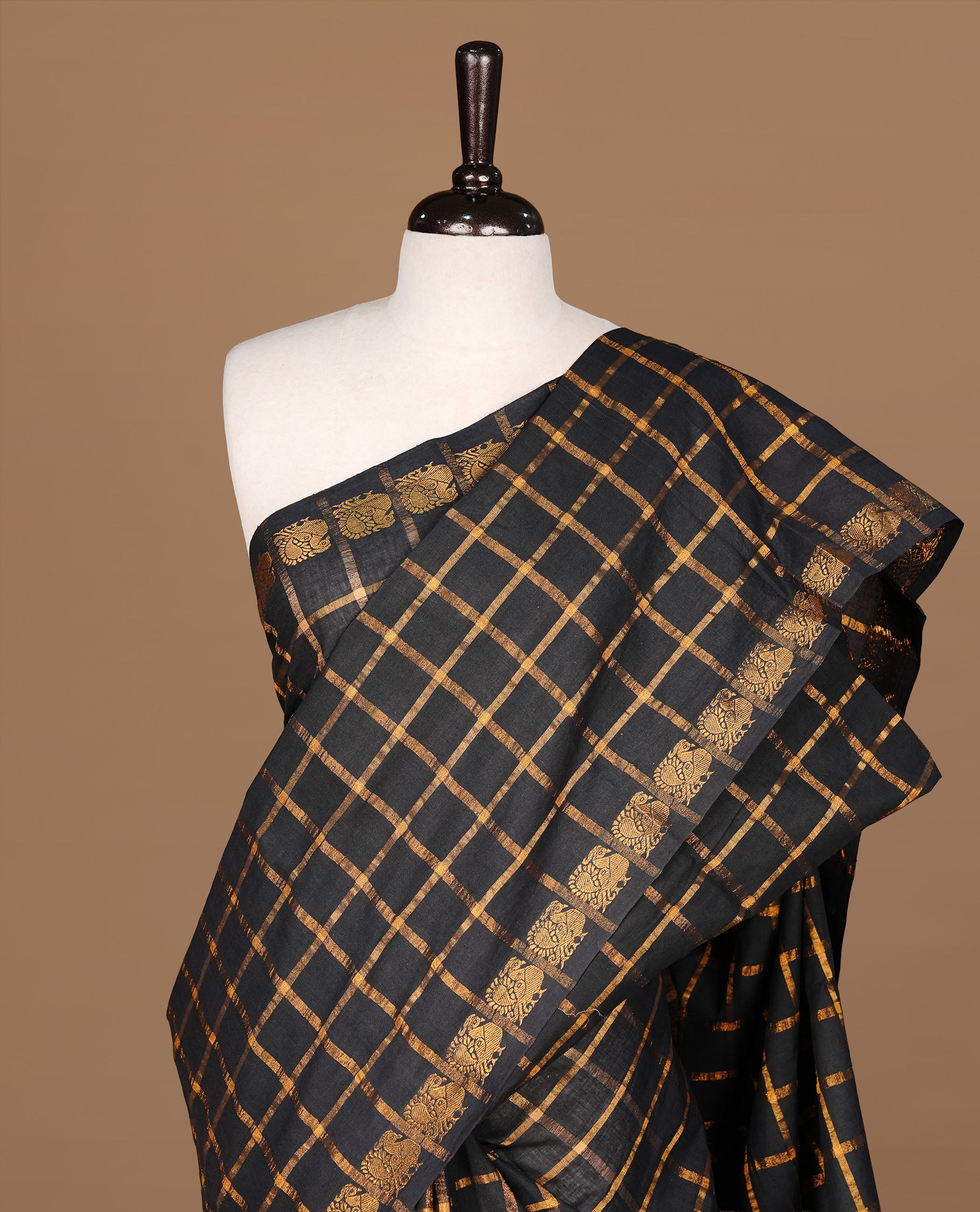 Black colour Sungudi cotton saree Featuring gold Zari check on body, complemented by gold zari peacock motif on self colour border, paired with matching blouse piece.