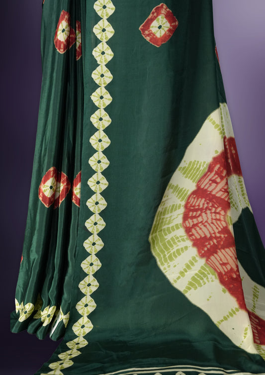 Dark green colour saree with red, white & yellow motifs, diamond border, and bold pallu & Comes with a paired matching blouse.