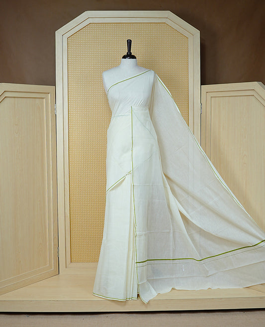 Cream colour cotton Kerala saree Featuring Classy Plain body for Effortless Elegance, enhancing Minimalist Green border, paired with matching blouse piece.