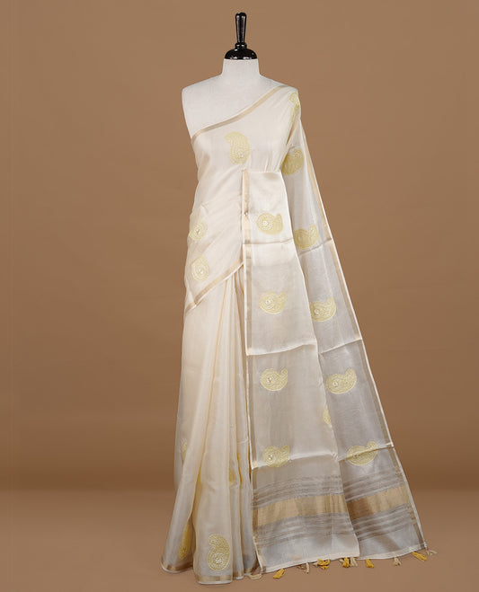 Cream colour Tussar saree featuring yellow colour Mango pattern with chikankari embroidery work, highlighting gold zari simple border, paired with matching unstitched blouse.