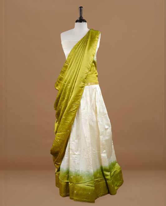 Off white colour semi stitched half saree featuring elegant zari buttas on the body, paired with a contrast pastel green border and matching striped dupatta,paired with matching blouse piece.