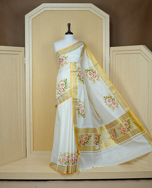 Cream Colour Kerala Saree Featuring Gold Zari Checks On The Body, Enhanced By A Gold Zari Border With Floral Prints And A Matching Pallu, Paired With A Matching Blouse Piece.
