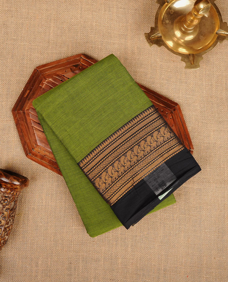 Green colour chettinad cotton saree featuring plain body, paired with a charcoal black colour traditional gold zari border without blouse.