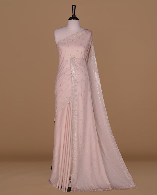 Light peach colour organza designer saree featuring Gold stone motifs on body, highlighting light weight stone worked border, paired with matching blouse piece.