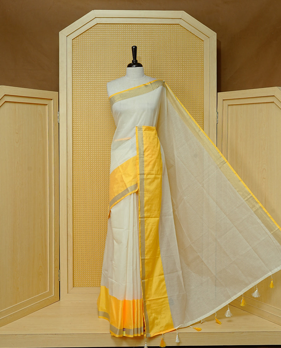Cream colour Cotton kerala Saree featuring Plain body, Big yellow & gold kasavu border, comes with matching blouse piece.