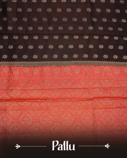 Chocolate colour Banaras tussar silk saree featuring elegant gold zari buttas across the body, complemented by a contrast Red border with rich zari detailing. Comes paired with a matching blouse piece.