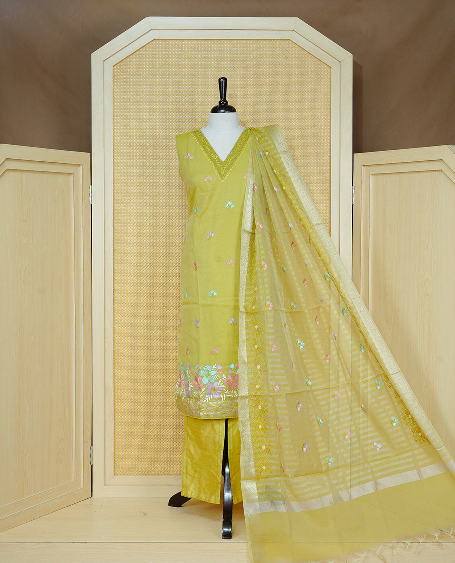 Lemon green colour churidar set with a beaded V-neckline, pastel floral buti embroidery and floral hem detailing, paired with a matching embroidered bordered dupatta and solid pants.