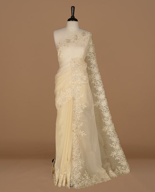 Pastel yellow colour organza saree featuring thread with cut beats & sequins floral pattern on body, highlighting scalp border, paired with matching blouse piece.