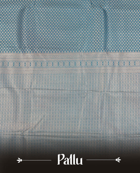 Teal colour semi silk brocade saree featuring intricate Gold patterns across the body, complemented by a Self colour woven border and pallu, paired with a matching blouse.