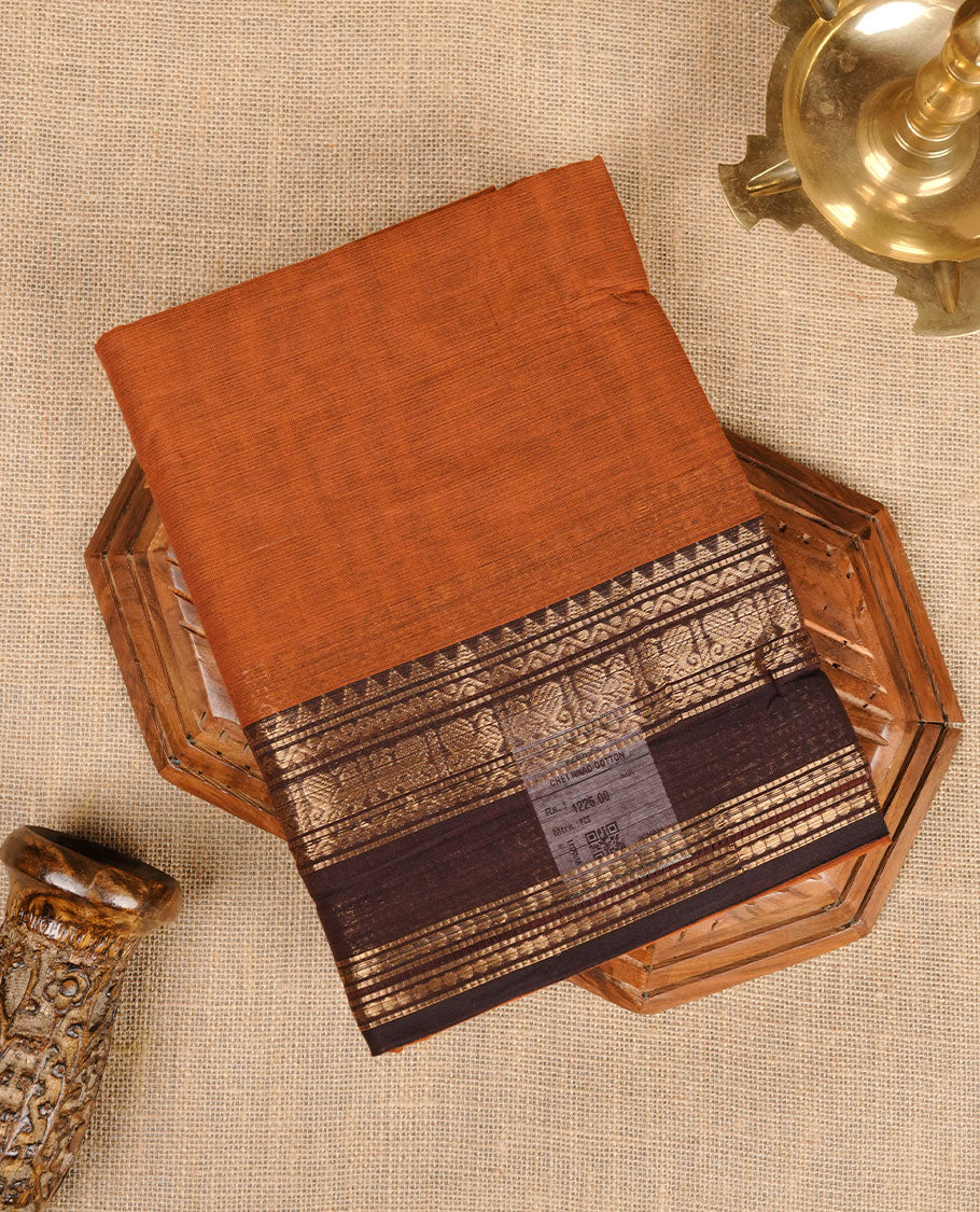 Burnt orange colour chettinad cotton saree featuring plain body, contrast Chocolate brown colour with traditional gold zari border paired with matching blouse.