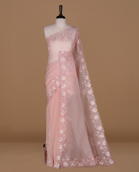 Pinkish beige colour organza saree featuring thread with cut beats & sequins floral pattern on body, highlighting scalp border, paired with matching blouse piece.