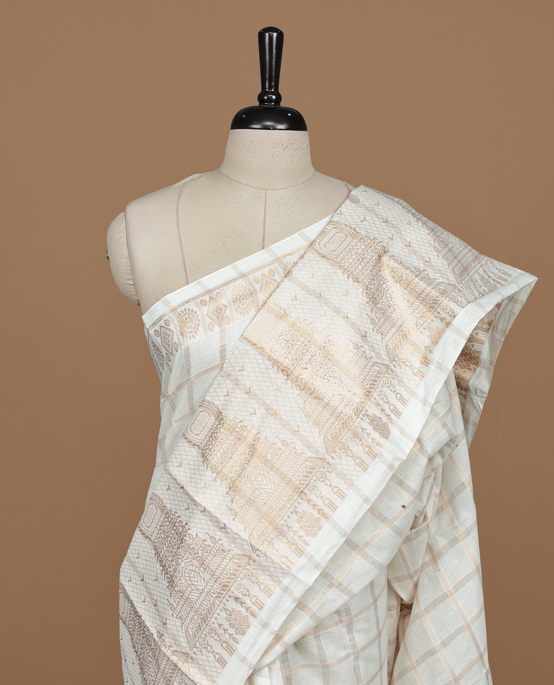 Off white colour Sungudi cotton saree featuring Gold zari checks on body, Gold zari temple design on Self colour border, paired with matching blouse piece.