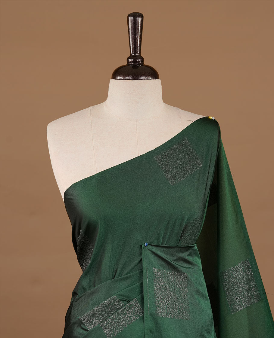 Green soft silk saree features a sleek borderless design with intricate antique zari motifs, flowing into a seamless self colored pallu and a matching blouse piece.