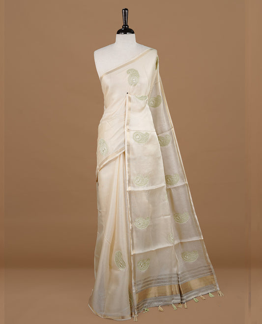 Cream colour Tussar saree featuring Light green colour Mango pattern with chikankari embroidery work, highlighting gold zari simple border, paired with matching unstitched blouse.