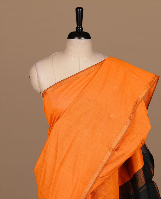 Orange colour Maheshwari cotton saree features elegant gold zari motifs across the body, a classic gold zari border, a striking contrast pallu, and a matching blouse piece.