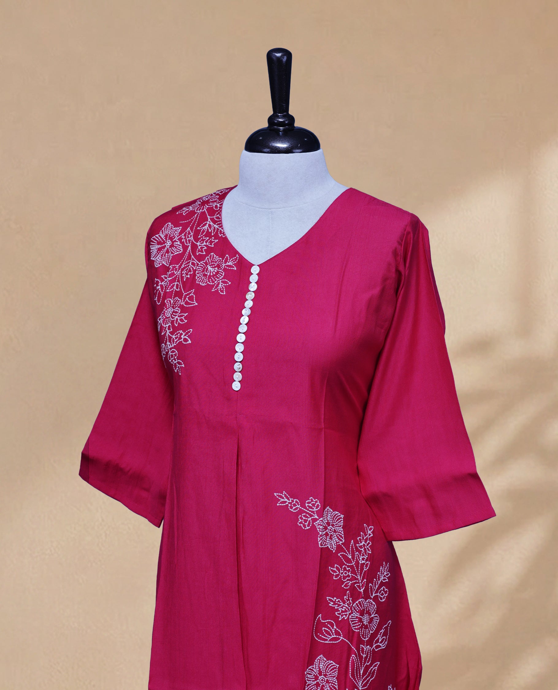 Rani Pink Kurti featuring a Floral Prints On body, a U-shaped neckline adorned with floral print and button work, and a 3/4-sleeve design.