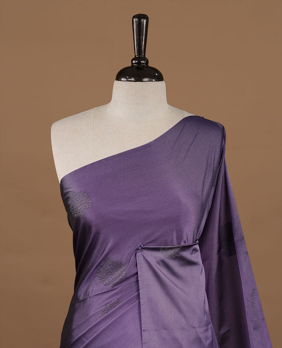 Lavender soft silk saree features a sleek borderless design with intricate antique zari motifs, flowing into a seamless self colored pallu and a matching blouse piece.