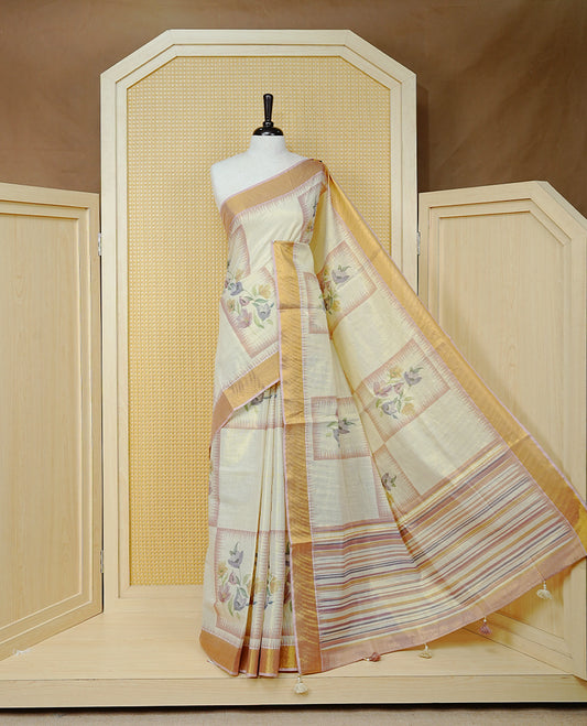 Cream Colour Tissue  Kerala Saree Featuring Floral Prints in a Stylish Rectangle Pattern On Body, Enhanced with a Gold Zari Border and a Multicoloured Striped Pallu. Finished with Elegant Tassels and Paired with a Matching Blouse Piece.