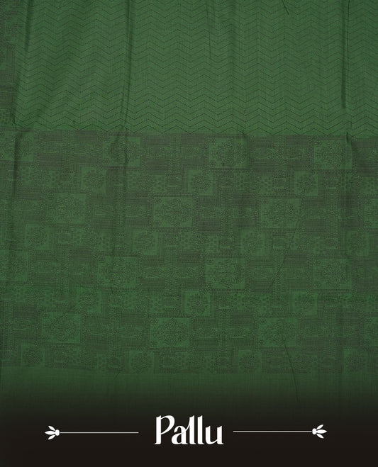 Dark green colour poly cotton saree with black zigzag line pattern on the body, paired with a matching pallu featuring black chevron lines and panelled floral‑paisley design, and a coordinated all‑over floral paisley patch‑style printed blouse piece.