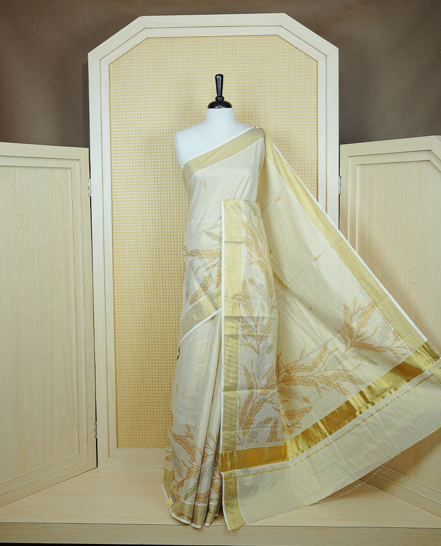 Light gold colour tissue Kerala saree featuring Leaf print & Gold zari check on body, complemented by gold Border, comes with matching blouse piece.