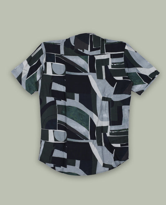 Dark green colour shirt featuring bold abstract geometric prints in shades of black, white, and grey & Designed with a classic collar and short sleeves, it offers a trendy, artistic look perfect for casual outings.
