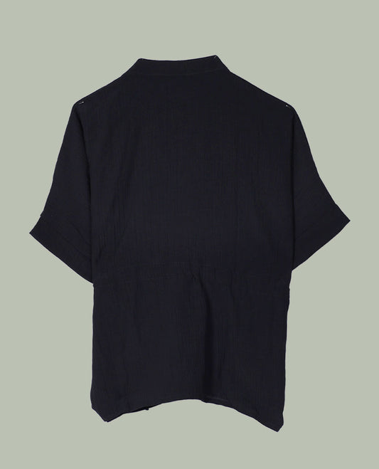 Black short-sleeve top with V-slit band neckline, contrast ivory crochet motif on one side, and adjustable drawstring detail at the waist.