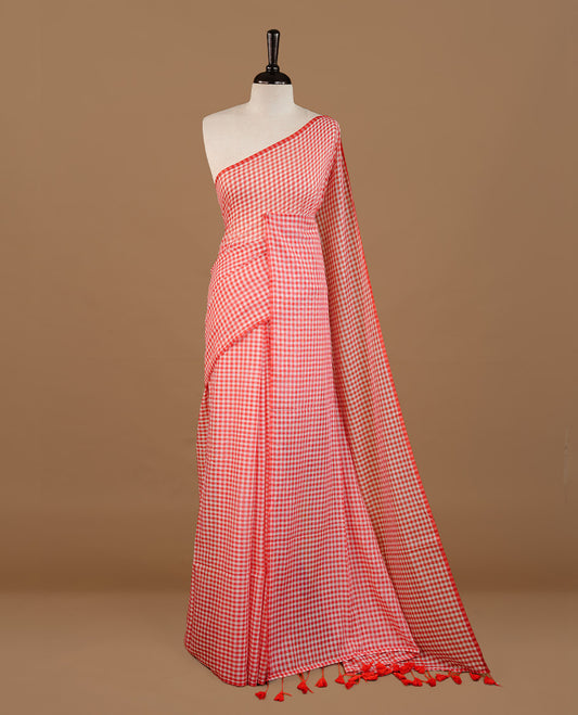 Red and White colour Mul Cotton saree featuring a classic small check pattern on the body, accented with tassels for added charm. Comes without a blouse piece.