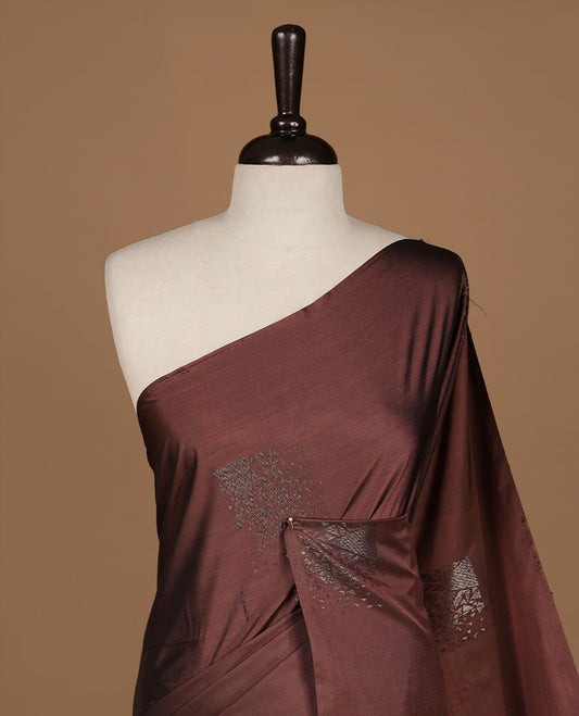 Chocolate soft silk saree features a sleek borderless design with intricate antique zari motifs, flowing into a seamless self colored pallu and a matching blouse piece.