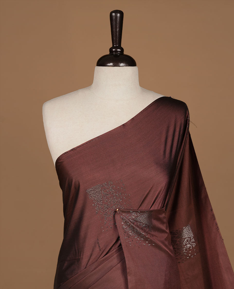 Chocolate soft silk saree features a sleek borderless design with intricate antique zari motifs, flowing into a seamless self colored pallu and a matching blouse piece.
