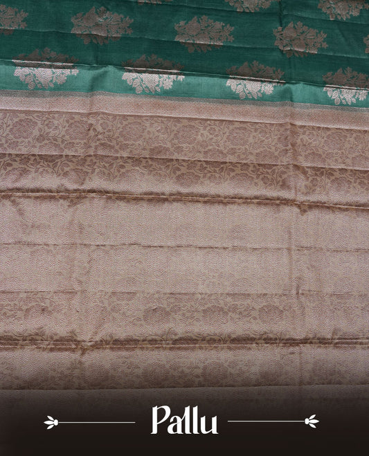 Green colour pure banaras tusser silk saree highlighting antique zari pattern across body, with contrast cream colour with zari border and paired with matching blouse