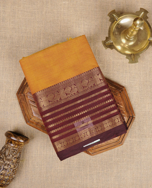 Dusty orange colour chettinad cotton saree featuring plain body, paired with a choclate brown colour traditional gold zari border paired with matching blouse.