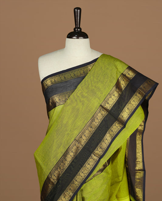 Olive Colour chettinad cotton saree featuring Elegant plain body, complemented by contrast Dark blue colour with gold zari border, paired with matching blouse.