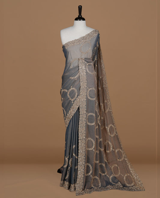 Blue colour organza saree featuring thread & gold stone pattern on body, highlighting scalp border, paired with mtahcing blouse piece.