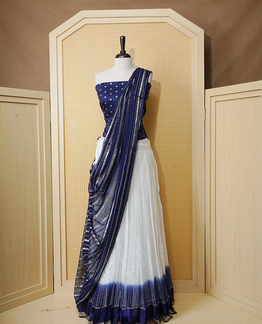 Off white colour Semi stitched dhavani set featuring Gold zari check pattern with contrast Navy blue border skirt, paired with matching blouse & dupatta.
