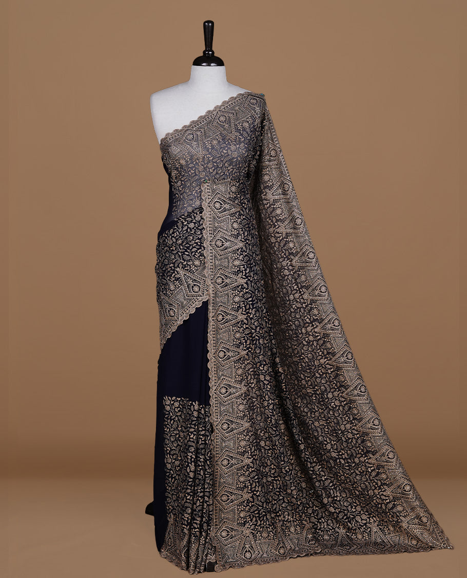 Dark blue colour georgette designer saree featuring Gold thread floral pattern on body highlighting with stone and scalp border, paired with matching blouse piece.