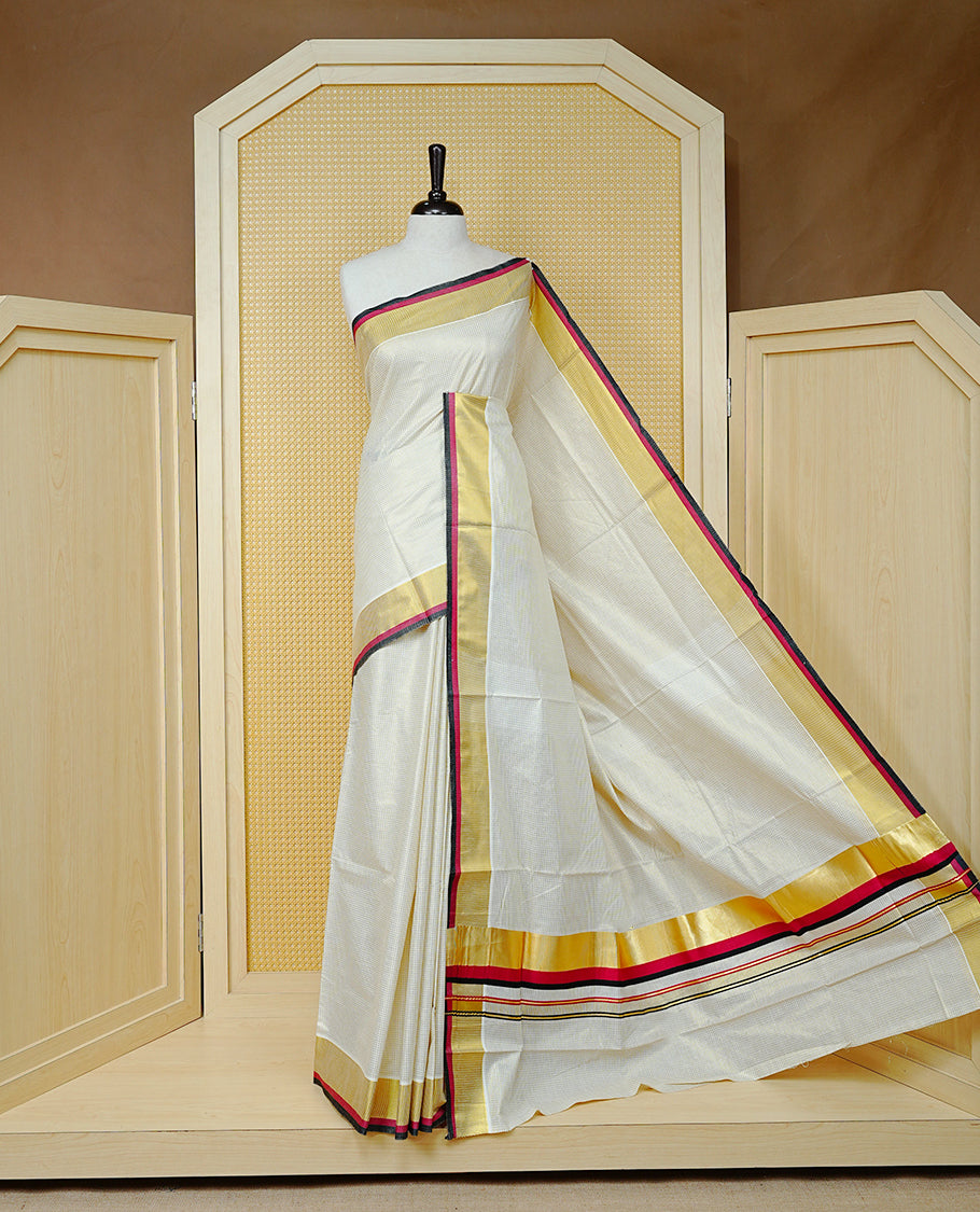 Cream colour cotton Kerala saree Featuring Gold zari Checks across the body, complemented by Classy Gold zari with an Maroon  &  Black  Border & pallu, paired with a matching blouse piece.