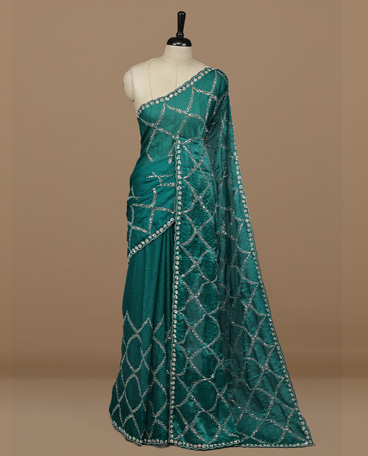 Teal colour designer saree featuring Sequins & cut beats worked body, cut beat worked border, paired with matching unstitched blouse.