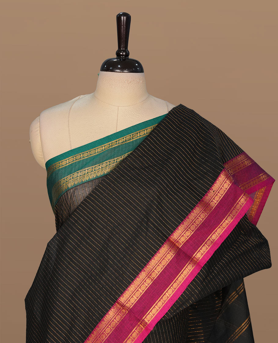 Black colour chettinad cotton featuring gold zari check pattern on body , complemented by contrast teal & magenta double colour with gold zari border, paired with matching blouse piece.