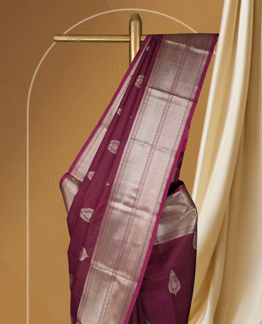 Wine colour soft silk saree beautifully adorned with silver zari buttas, paired with a rich silver zari border and pallu & Completed with a matching blouse.